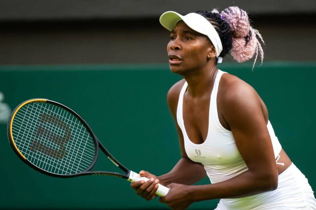 Venus Williams habillée en blanc en plein match de tennis